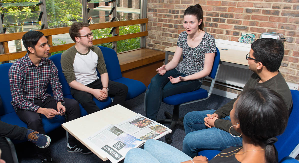 Students sit around a table chatting